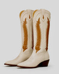 Pair of cream-colored cowboy boots with brown decorative patterns on a light gray background