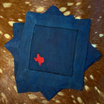 Navy linen-cotton cocktail napkin with red embroidered Texas silhouette styled on cowhide