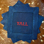Navy linen-cotton cocktail napkin with red Y’all embroidery styled on cowhide