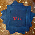 Navy linen-cotton cocktail napkin with red Y’all embroidery styled on cowhide